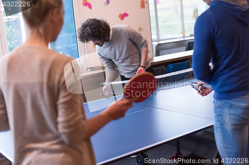 Image of startup business team playing ping pong tennis