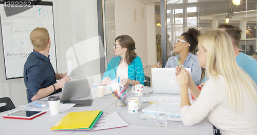 Image of Young coworkers exploring graphic in office