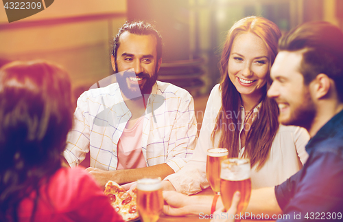 Image of friends eating pizza with beer at restaurant