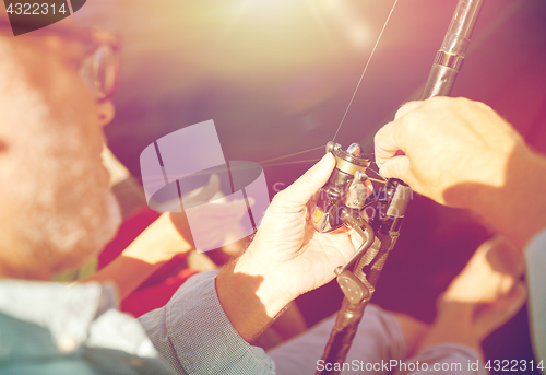 Image of senior man with fishing rod or spinning on river