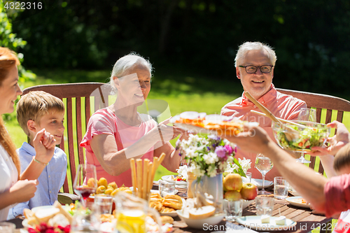 Image of happy family having dinner or summer garden party