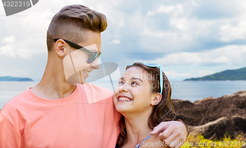 Image of happy teenage couple hugging outdoors