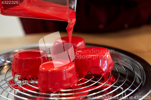 Image of jug pouring glaze to cakes at pastry shop