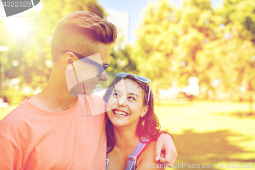 Image of happy teenage couple looking at each other in park