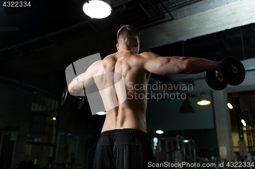 Image of close up of man with dumbbells exercising in gym