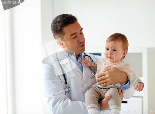 Image of doctor holding crying baby at clinic