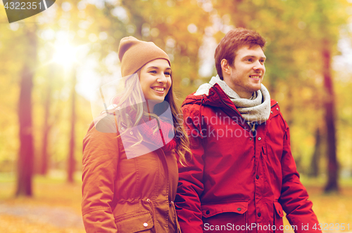 Image of happy young couple walking in autumn park