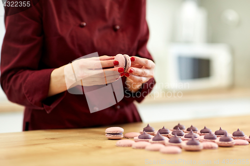 Image of chef sandwiching macarons shells with cream