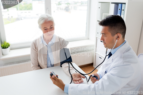 Image of senior woman and doctor with tonometer at hospital