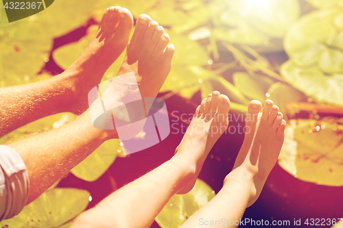 Image of grandfather and grandson feet over river