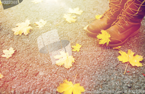 Image of female feet in boots and autumn leaves