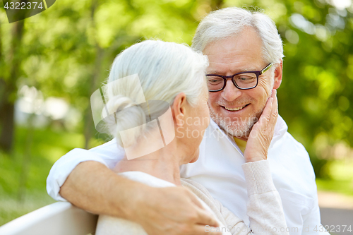Image of happy senior couple hugging in city park