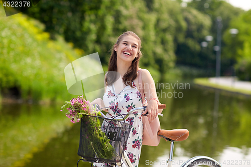 Image of happy woman riding fixie bicycle in summer park