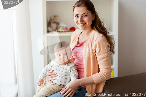 Image of happy young mother with little baby at home