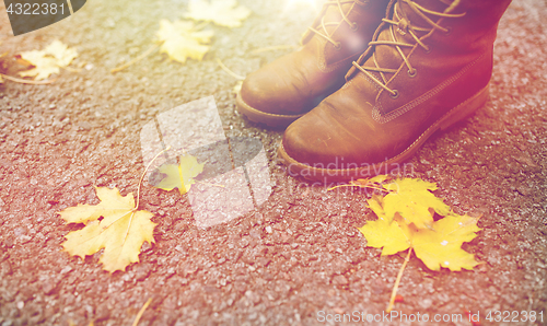 Image of female feet in boots and autumn leaves