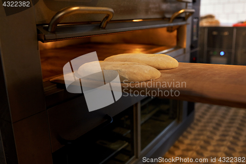 Image of yeast bread dough on oven tray at bakery kitchen