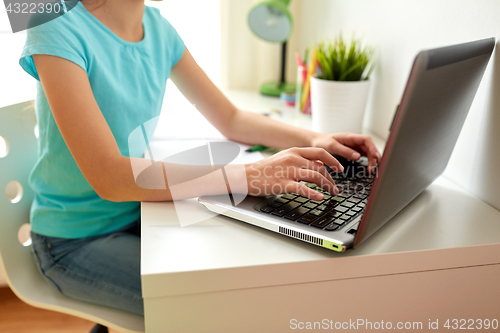 Image of girl typing on laptop at home