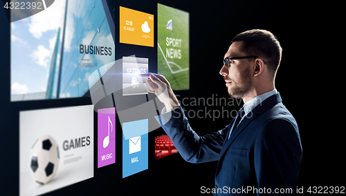 Image of businessman with applications on virtual screen