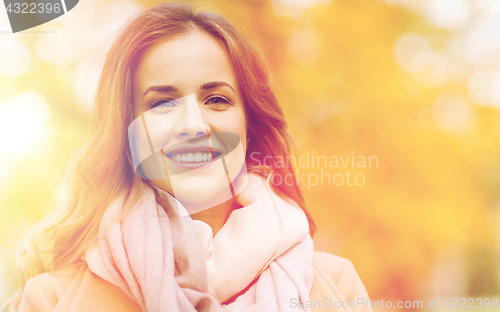 Image of beautiful happy young woman smiling in autumn park