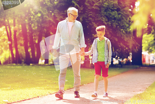 Image of grandfather and grandson walking at summer park