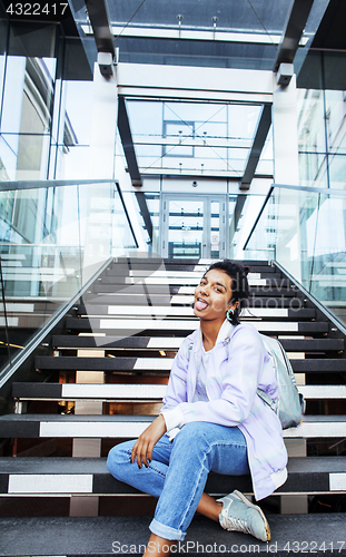 Image of young cute indian girl at university building sitting on stairs 