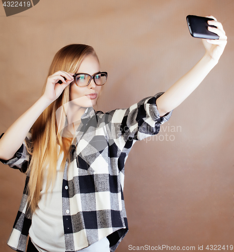 Image of young pretty blond woman with smartphone posing smiling, making 