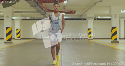 Image of Girl with longboard on parking