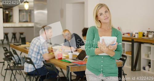 Image of Confident woman in office with coworkers