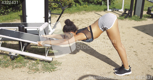 Image of Girl stretching in park gym