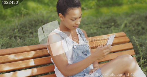 Image of Model taking selfie on bench