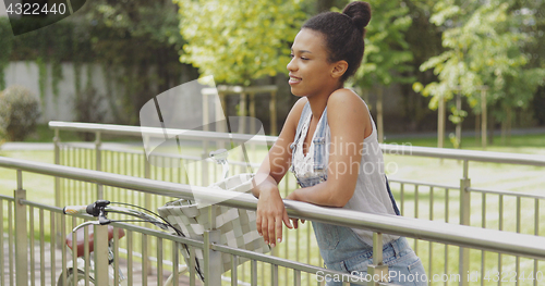 Image of Woman with bicycle on bridge