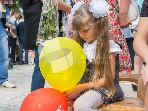 Image of Sad girl sitting with balls in hands on September 1 holiday
