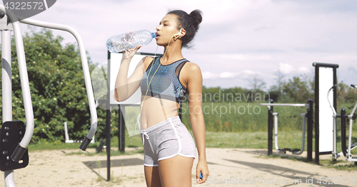 Image of Sportive girl drinking at workout