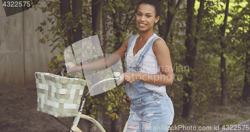 Image of Woman posing with bicycle at street