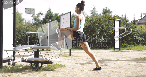 Image of Sportive woman stretching in park