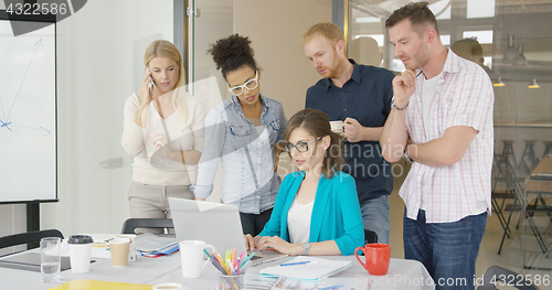 Image of Woman with coworkers watching laptop