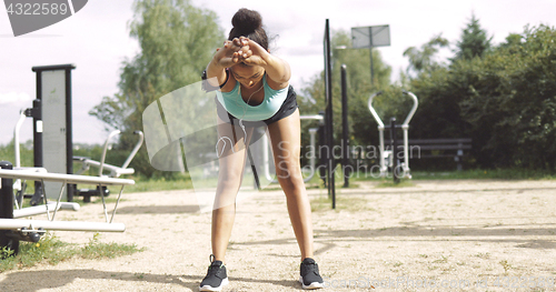 Image of Sportswoman warming up in park