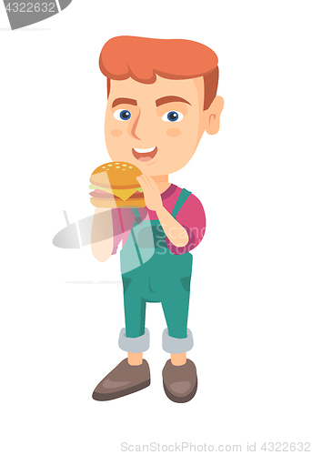 Image of Little caucasian boy eating a hamburger.