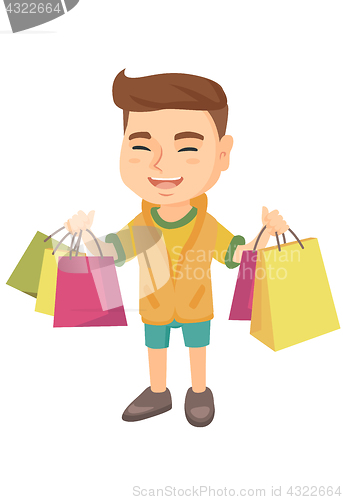 Image of Happy caucasian boy holding shopping bags.