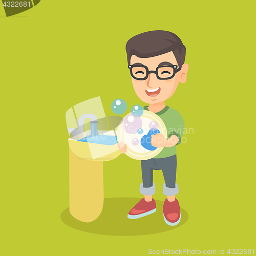 Image of Little caucasian boy washing dishes in the sink.