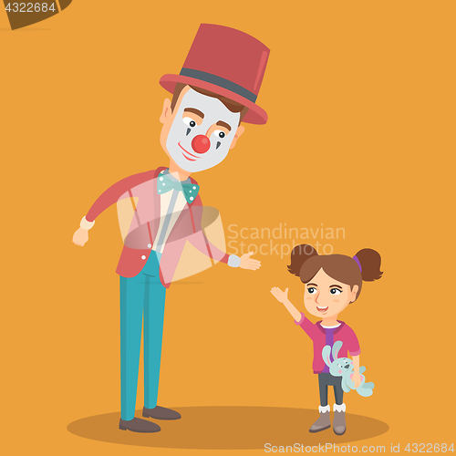 Image of Little caucasian girl playing with clown.