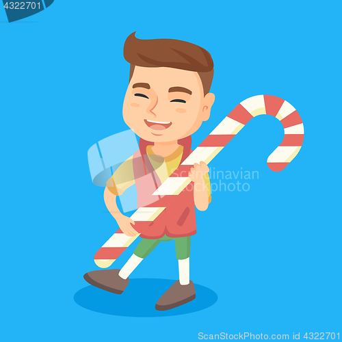 Image of Caucasian little boy holding christmas candy cane.