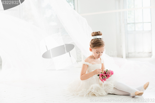 Image of The little balerina in white tutu in class at the ballet school