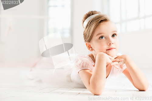 Image of The little balerina in white tutu in class at the ballet school