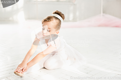 Image of Little ballerina girl in a tutu. Adorable child dancing classical ballet in a white studio.