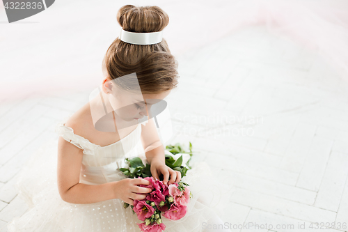 Image of The little balerina in white tutu in class at the ballet school