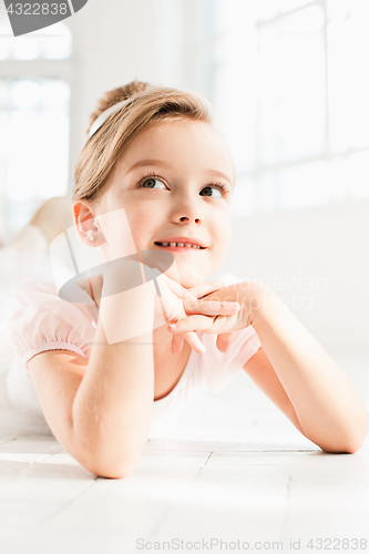 Image of The little balerina in white tutu in class at the ballet school