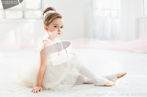 Image of The little balerina in white tutu in class at the ballet school