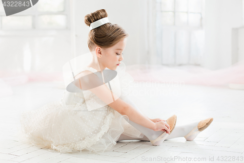 Image of The little balerina in white tutu in class at the ballet school