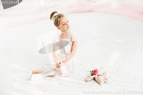 Image of The little balerina in white tutu in class at the ballet school